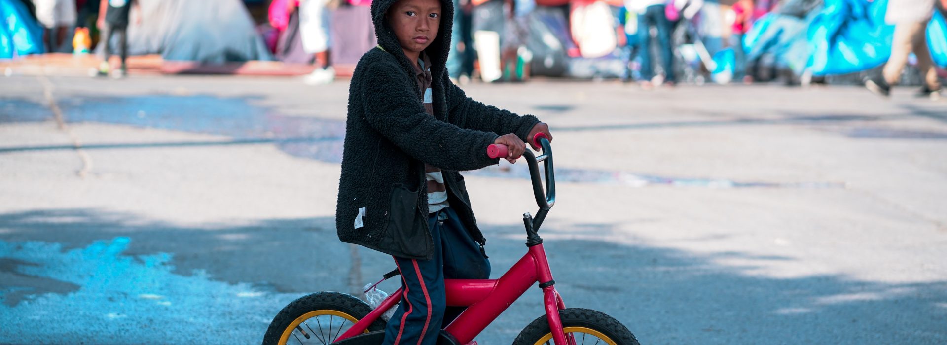 kisgyerek biciklin egy menekülttáborban